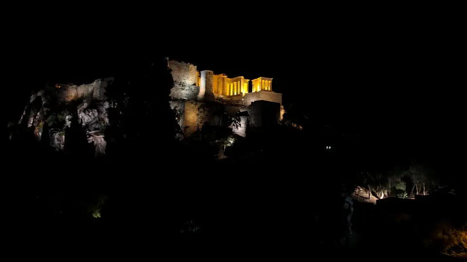 Widok nocą na oświetlony Akropol w Atenach.