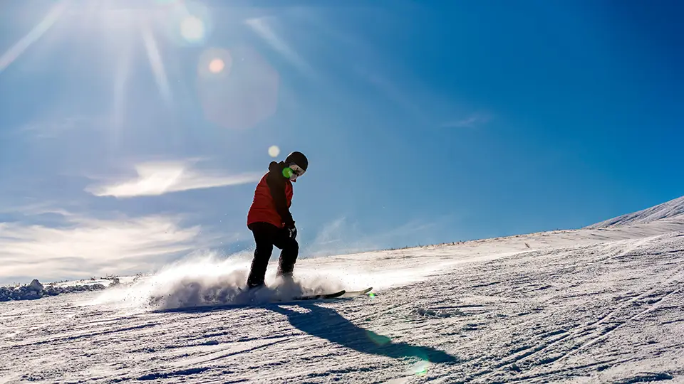 Narciarz na stoku, góry, słońce i przygoda