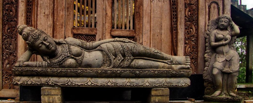 Posąg bogini leżącej na łóżku. Odpoczywająca naga kobieta wykuta w kamieniu. Wyspa Bali Indonezja.