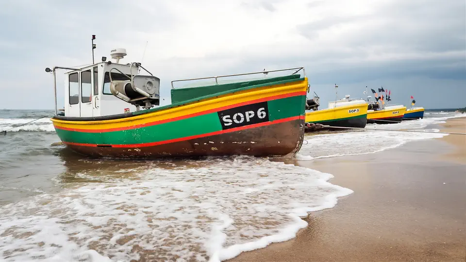 Sopot i kuter rybacki wyciągnięty na brzeg.
