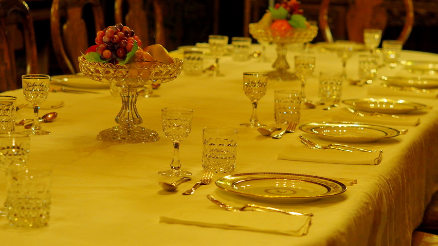 Stół w wiktoriańskim domu. Zastawiony szkłem i jedzeniem.