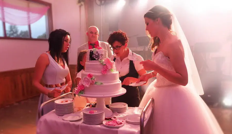 Panna młoda na kaszubskim weselu z tortem i innymi gośćmi