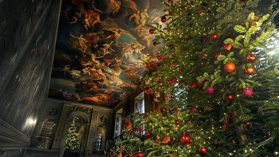 Choinka na Boże Narodzenie ustawiona w wielkiej sali za dębowymi drzwiami