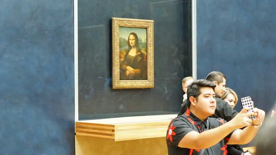 Luwr w Paryżu. Ludzie stoją w godzinnej kolejce by zrobić sobie selfie z obrazem Mona Lisa