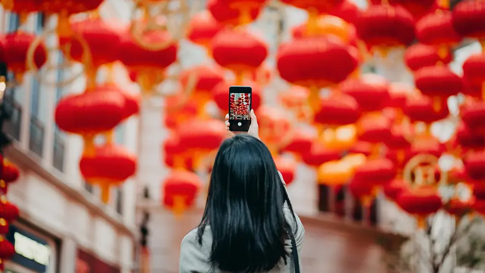 Dziewczyna na ulicy w Chinach pełnej lampionów robi selfie