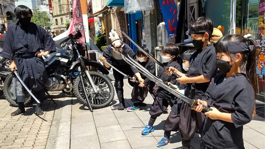 Dzieci ćwiczące mieczem na ulicy